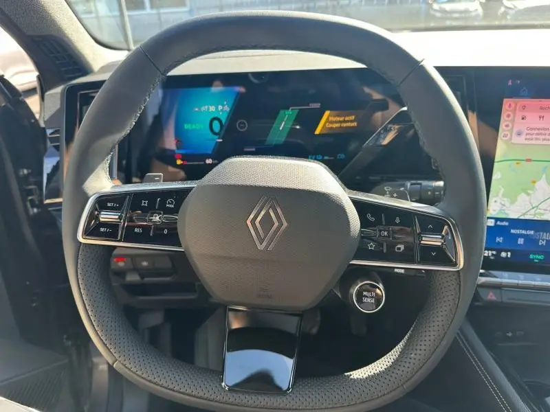 Vue intérieure centrée sur le volant multifonction noir du Renault Austral 2025 avec tableau de bord numérique et écran tactile.