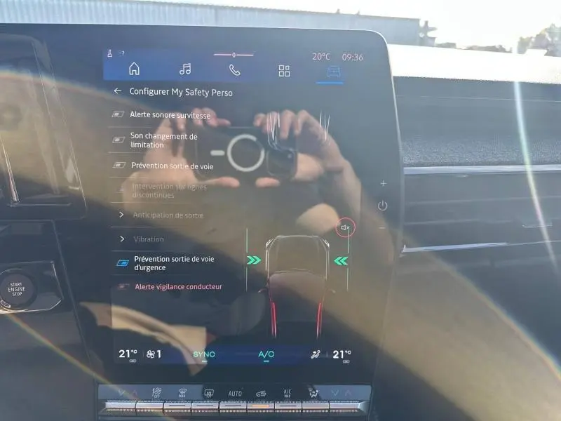 Écran tactile intérieur du Renault Austral 2025 affichant les options d’aide à la conduite, avec reflets et lumière naturelle.
