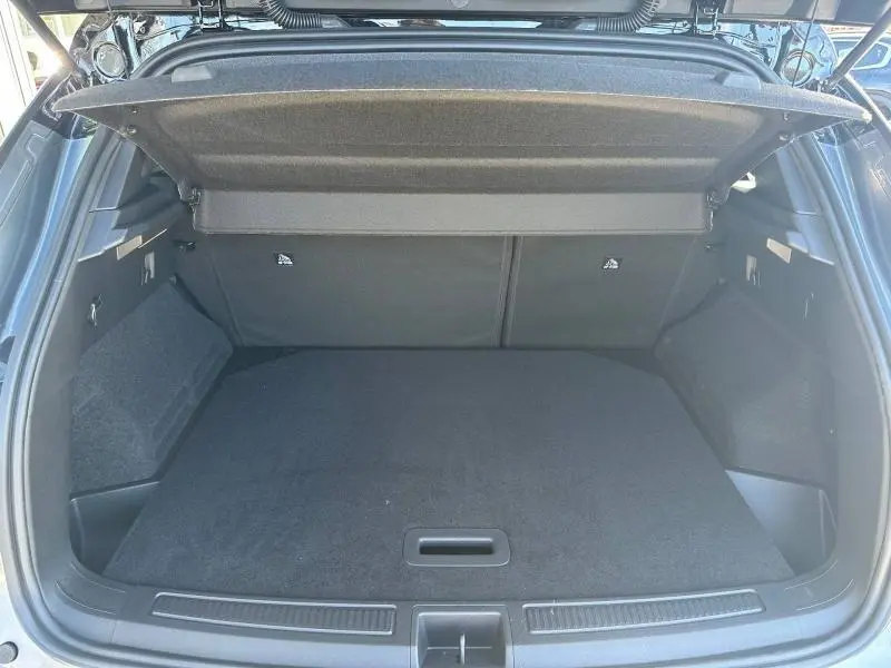 Coffre ouvert vu de l'arrière du Renault Austral 2025 gris Schiste avec cache-bagages relevé et espace de chargement visible.