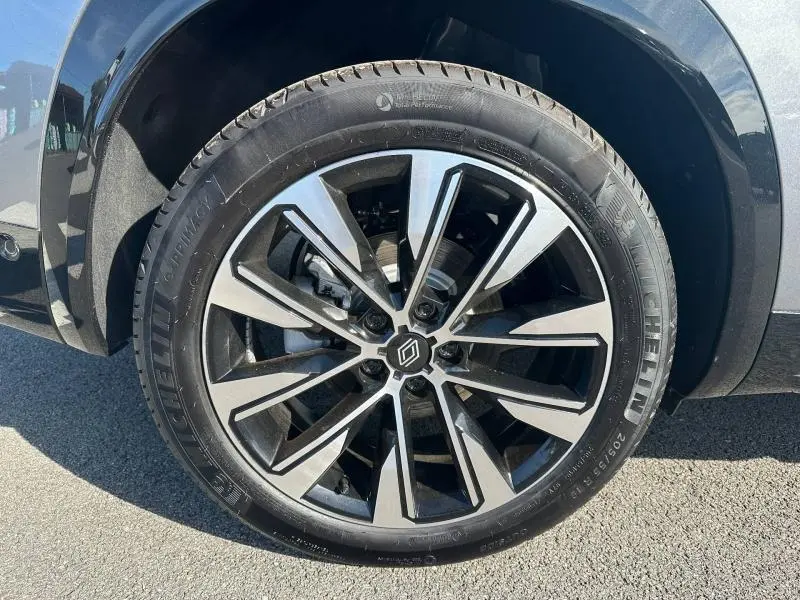 Gros plan sur la jante alu bicolore du côté avant droit d’un Renault Austral gris Schiste.