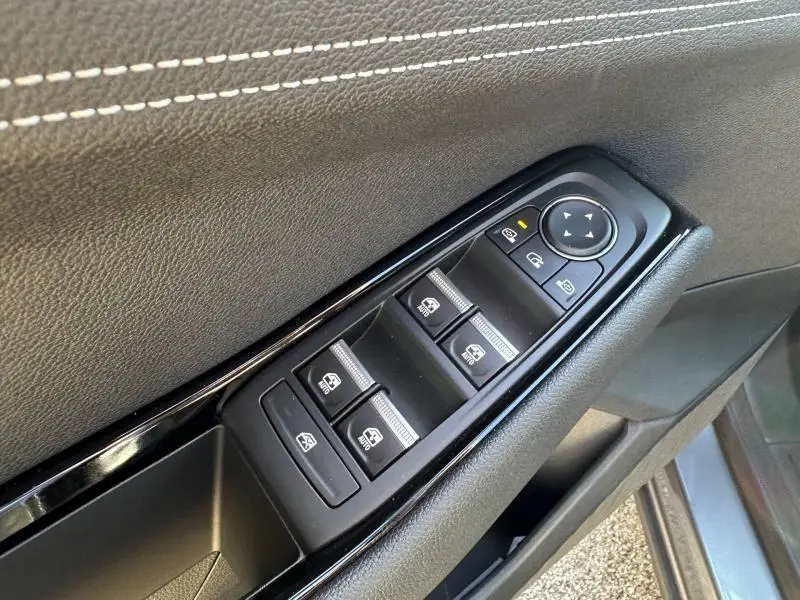 Gros plan sur les commandes des vitres électriques et rétroviseurs côté conducteur du Renault Austral gris Schiste.