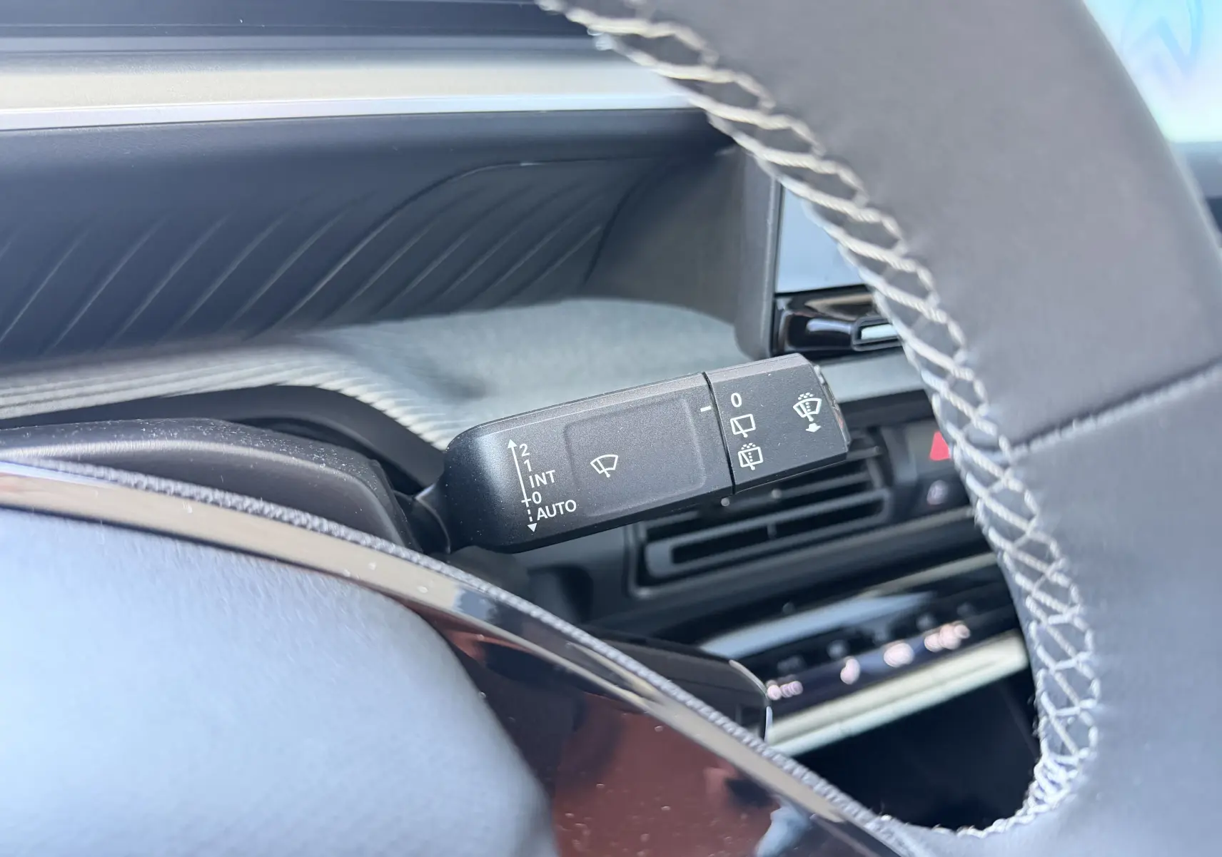 Gros plan sur la manette de commande des essuie-glaces côté gauche du volant de la Citroën E-C3 113 MAX gris Mercury.