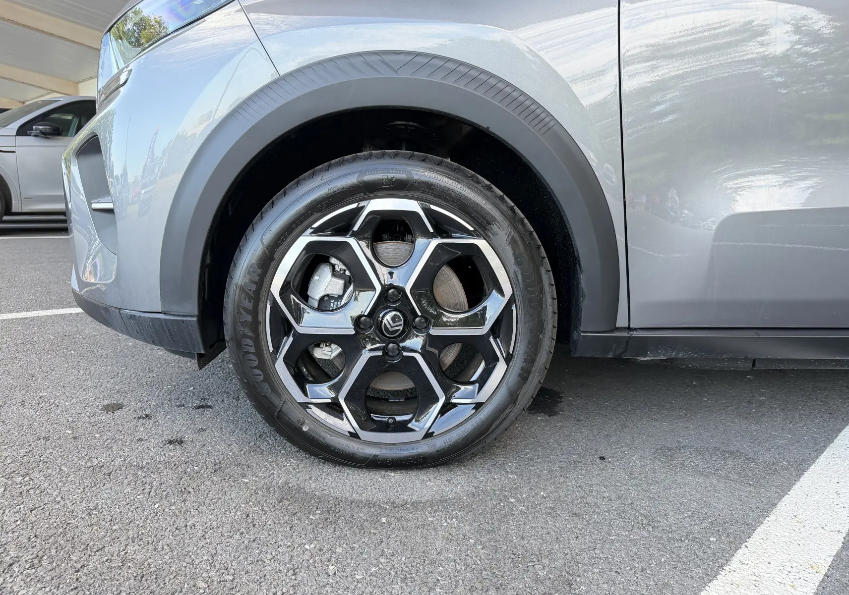 Gros plan sur la roue avant gauche de la Citroën E-C3 113 MAX gris Mercury avec jante alliage 17 pouces au design hexagonal.