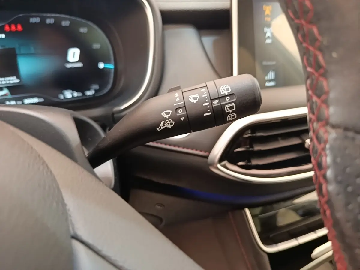 Gros plan sur la commande d’essuie-glace à gauche du volant dans l’habitacle noir du MG Motor EHS blanc 2023.