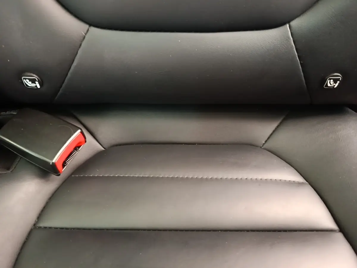Gros plan sur la banquette arrière en cuir noir du MG MOTOR EHS 1.5T PHEV, avec attaches Isofix visibles.