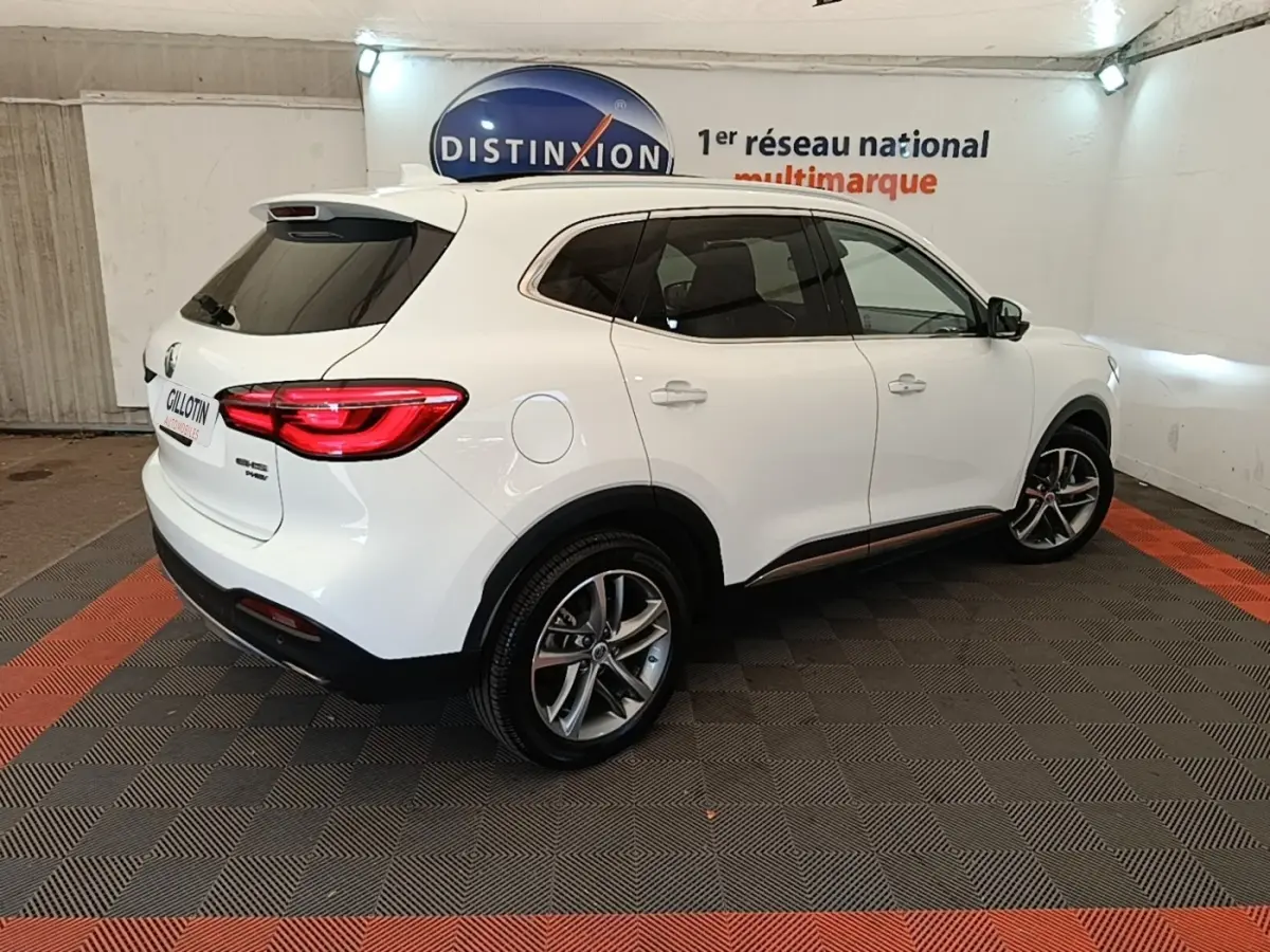 Vue 3/4 arrière droite du SUV blanc MG Motor EHS 1.5T GDI PHEV Luxury 2023 dans un showroom intérieur.
