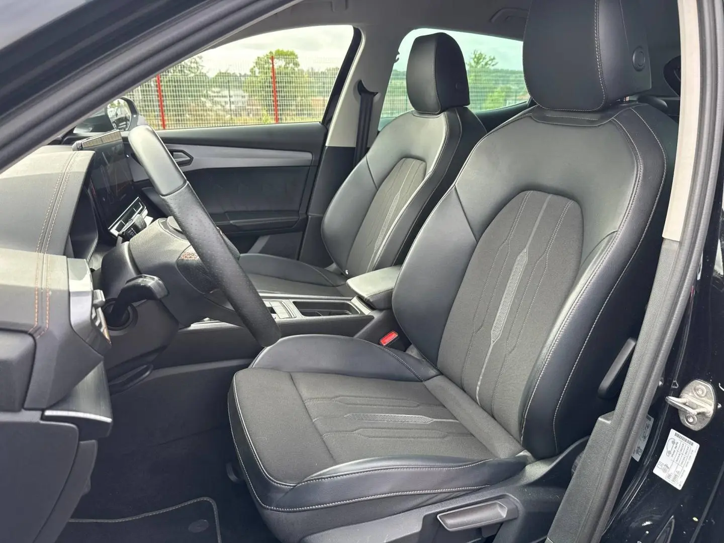 Vue intérieure côté conducteur du CUPRA Formentor 2.0 TDI 150ch 2023, sièges sport en tissu et similicuir noir avec surpiqûres cuivre.
