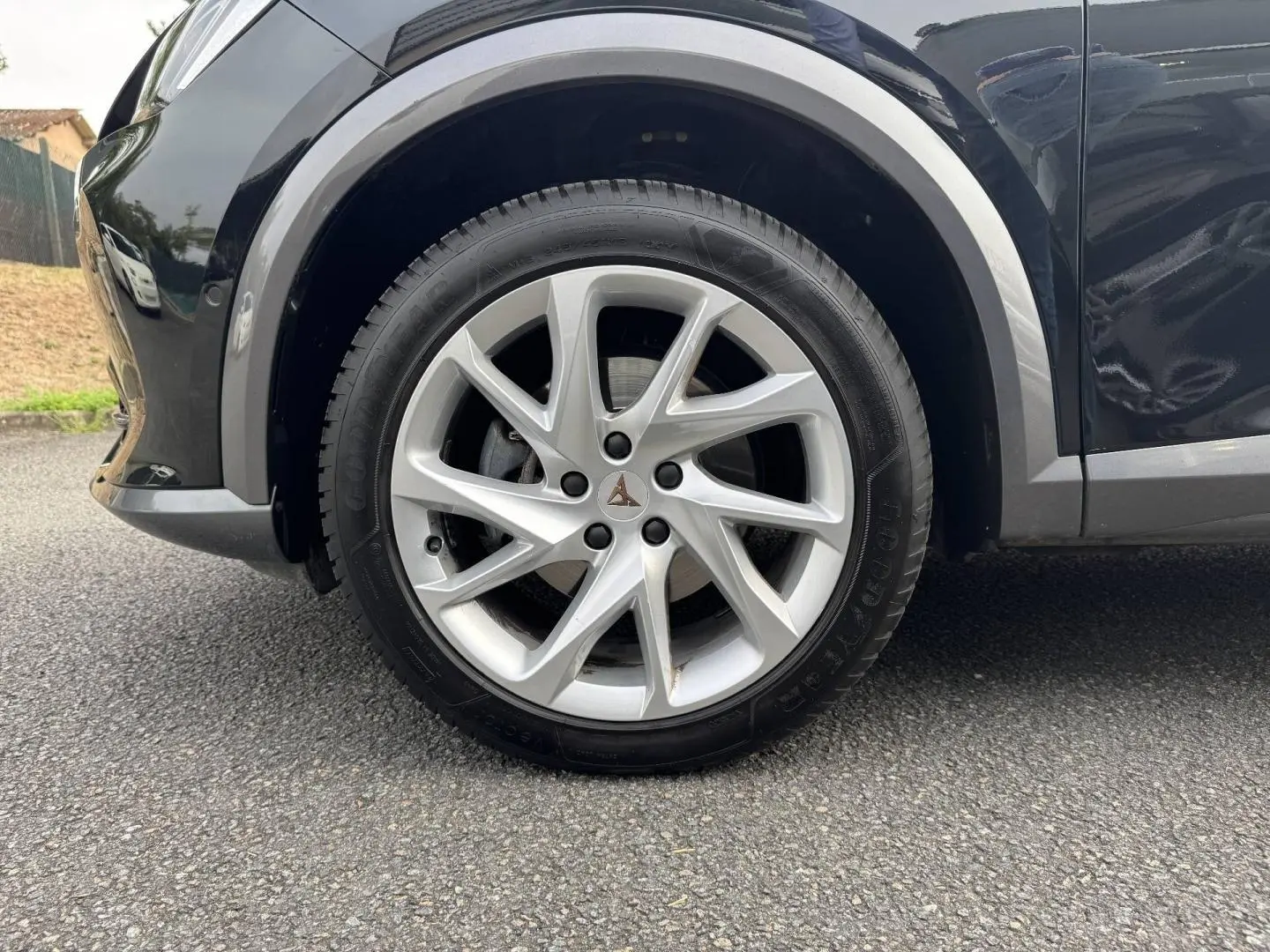 Gros plan sur la roue avant gauche avec jante alu argentée du CUPRA Formentor noir Minuit métallisé.