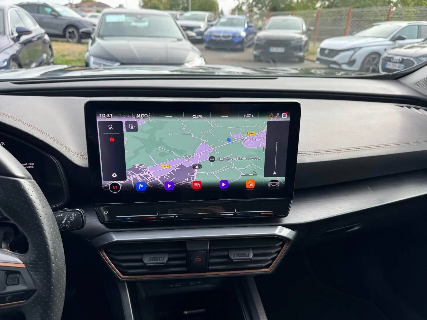 Vue intérieure du tableau de bord du CUPRA Formentor 2023 avec écran tactile GPS et volant sport en cuir noir.
