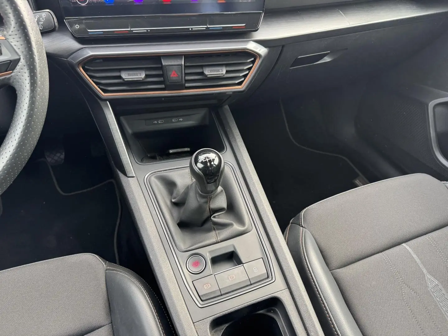 Vue rapprochée de la console centrale du CUPRA Formentor noir, mettant en valeur le levier de vitesse manuel et les sièges sport noirs.