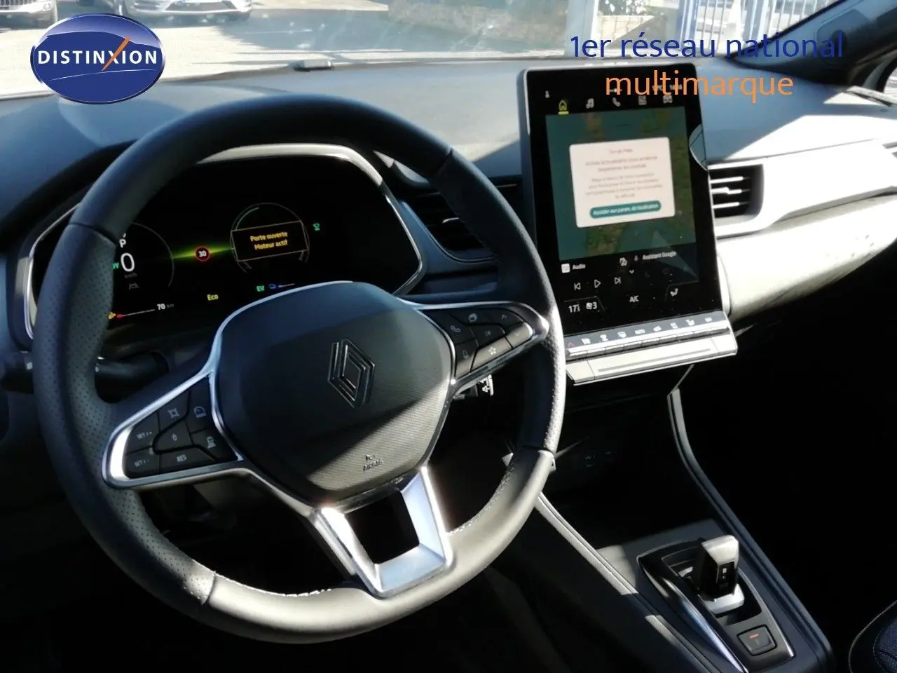 Intérieur du Renault Captur E-Tech 2026 vu du poste de conduite, volant cuir et écran tactile vertical.