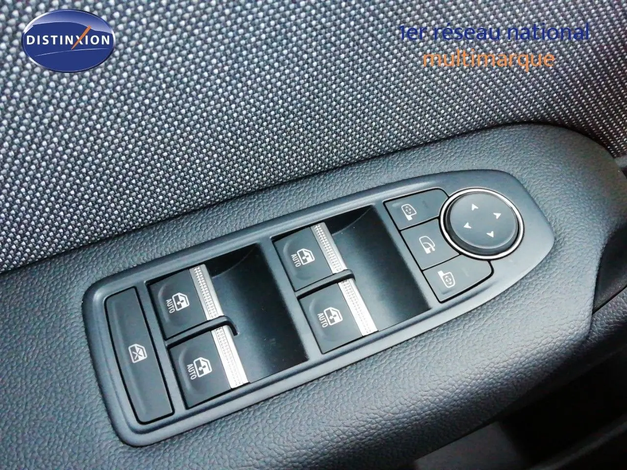 Gros plan sur les commandes des vitres électriques et rétroviseurs sur la portière côté conducteur d’un Renault Captur blanc nacré toit noir.