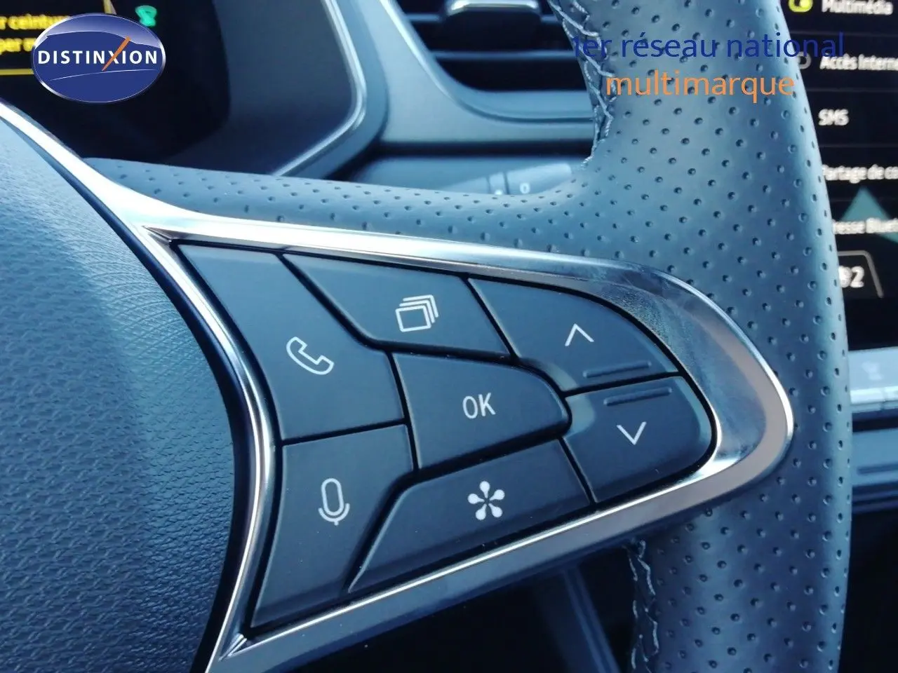 Gros plan sur les commandes multifonctions en cuir perforé du volant du Renault Captur blanc nacré 2026.