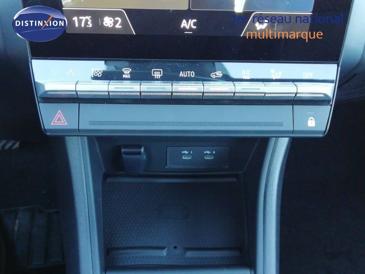 Vue rapprochée de la console centrale du Renault Captur blanc nacré avec toit noir, montrant les commandes climatisation et ports USB.