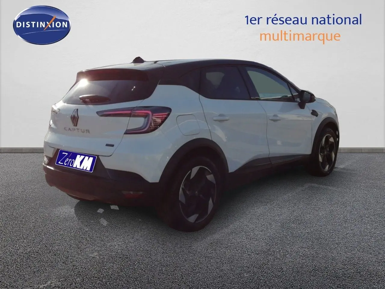 Vue 3/4 arrière droite du Renault Captur blanc nacré avec toit noir, soulignant ses jantes et lignes modernes.