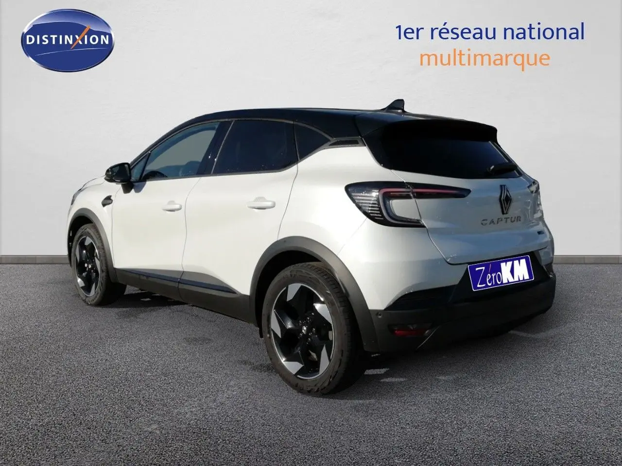 Vue 3/4 arrière droite du Renault Captur blanc nacré avec toit noir et jantes noires brillantes.