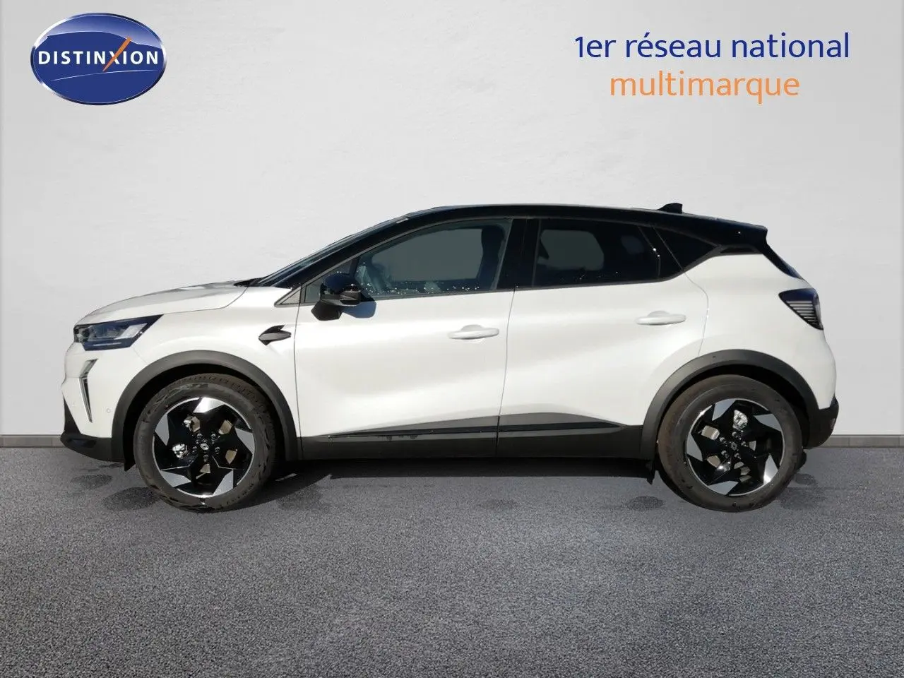 Profil latéral droit du Renault Captur blanc nacré avec toit noir, roues noires et détails modernes visibles.