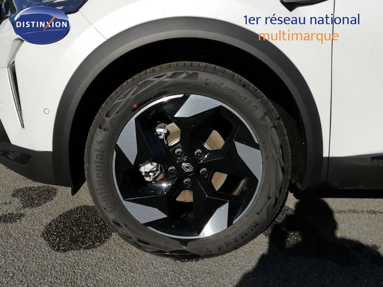 Gros plan sur la roue avant droite du Renault Captur blanc nacré avec jante noire et argentée en 2026.