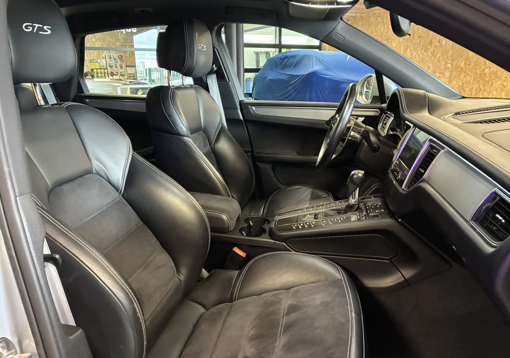 Intérieur noir cuir et alcantara du Porsche Macan GTS 2017, vue côté conducteur avec console centrale et sièges sport marqués GTS.