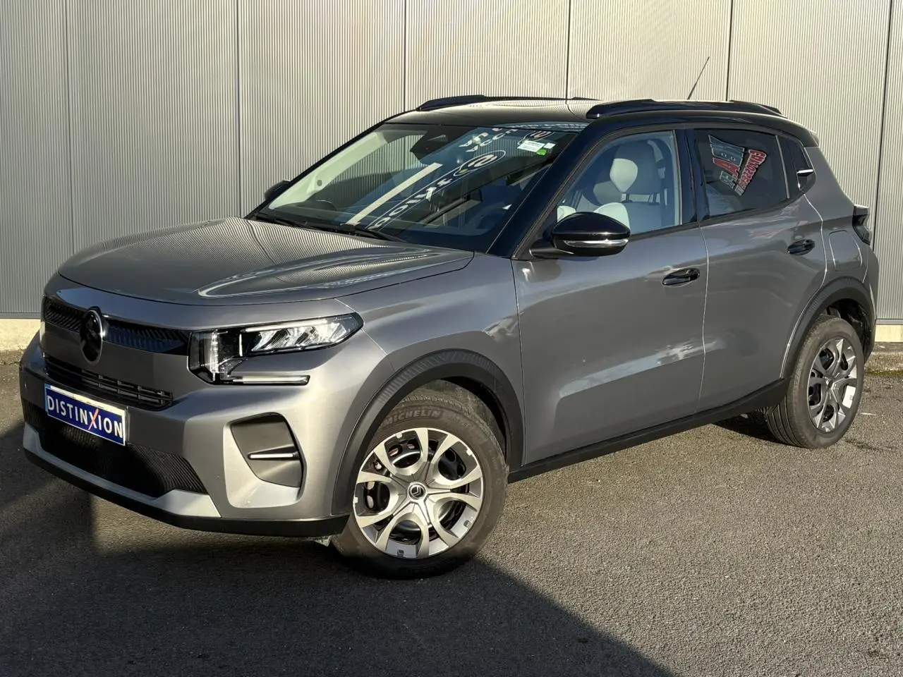 Vue 3/4 avant droite d'une Citroën C3 2025 gris Mercury avec toit noir et jantes alliage.