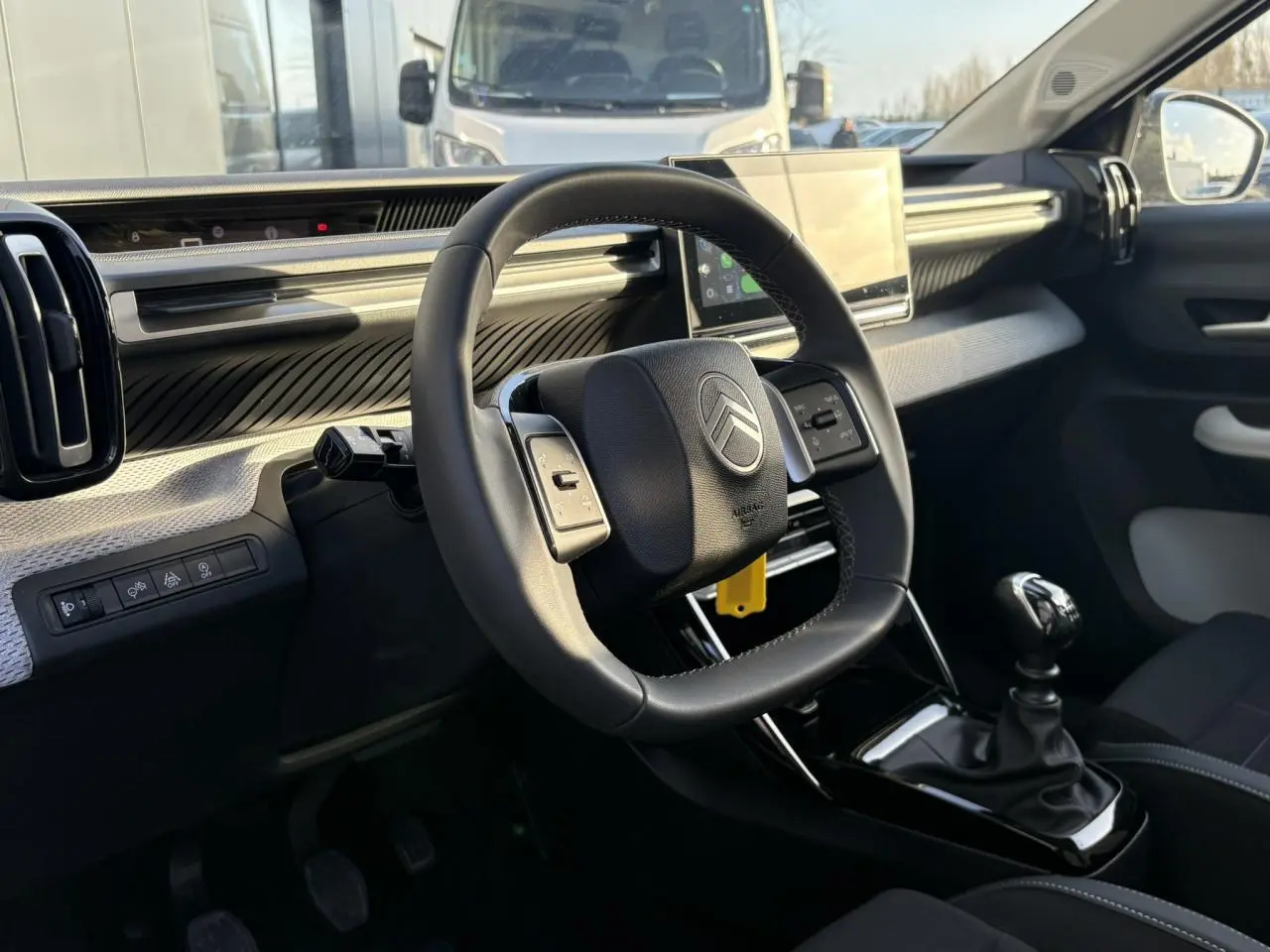 Vue intérieure côté conducteur du tableau de bord et volant de la Citroën C3 Turbo 100 Max avec écran tactile et boîte manuelle.