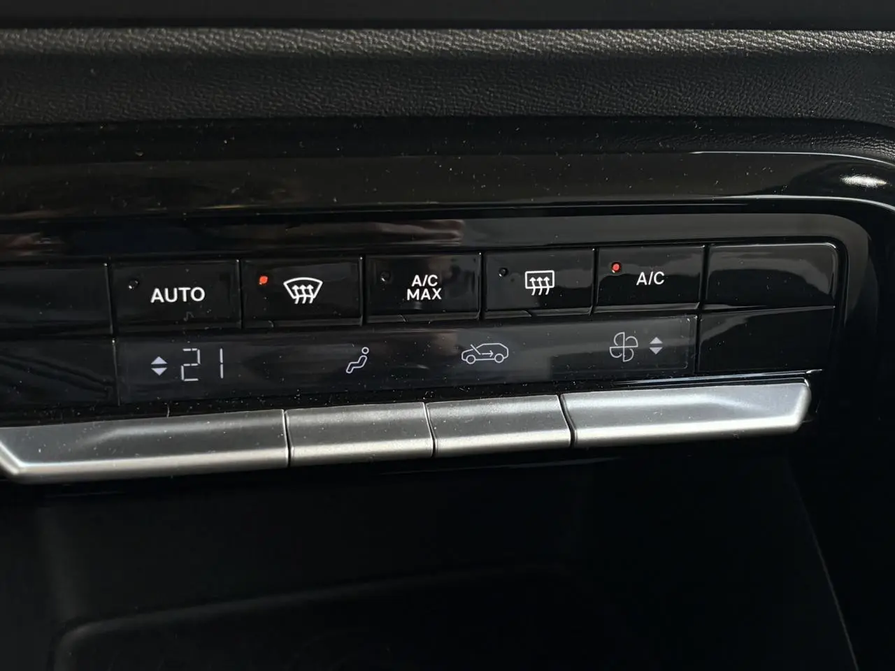 Gros plan sur la commande de climatisation automatique de la Citroën C3 Turbo 100 Max, finition noire brillante.