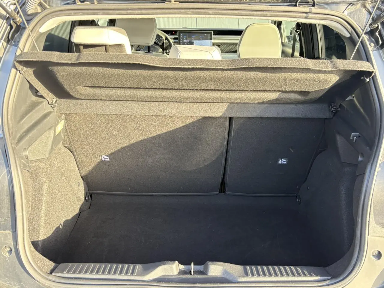 Vue du coffre ouvert d'une Citroën C3 2025 gris Mercury avec intérieur noir et sièges arrière visibles.