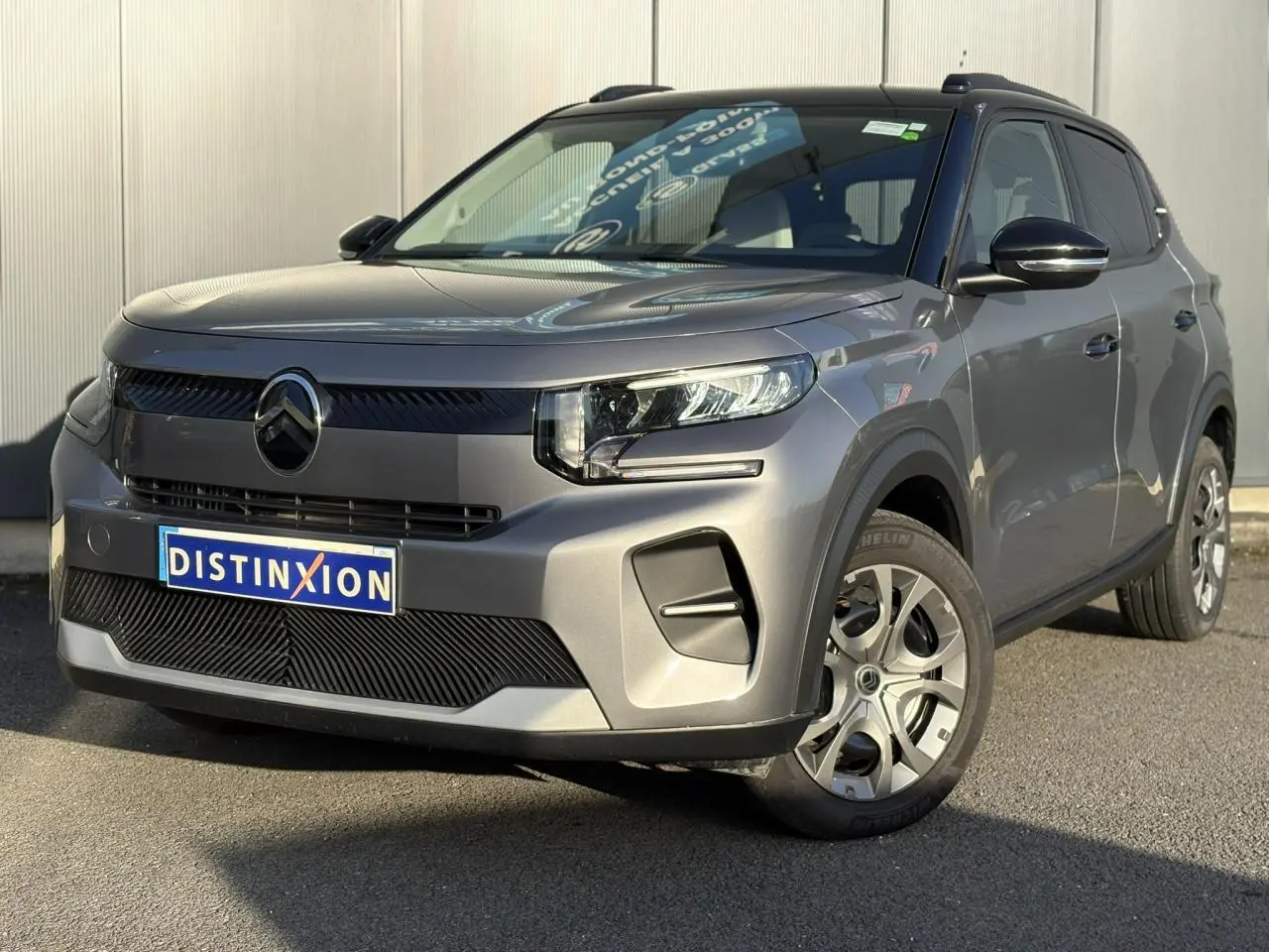 Vue 3/4 avant droite d'une Citroën C3 2025 gris Mercury avec toit noir et jantes alliage distinctives.