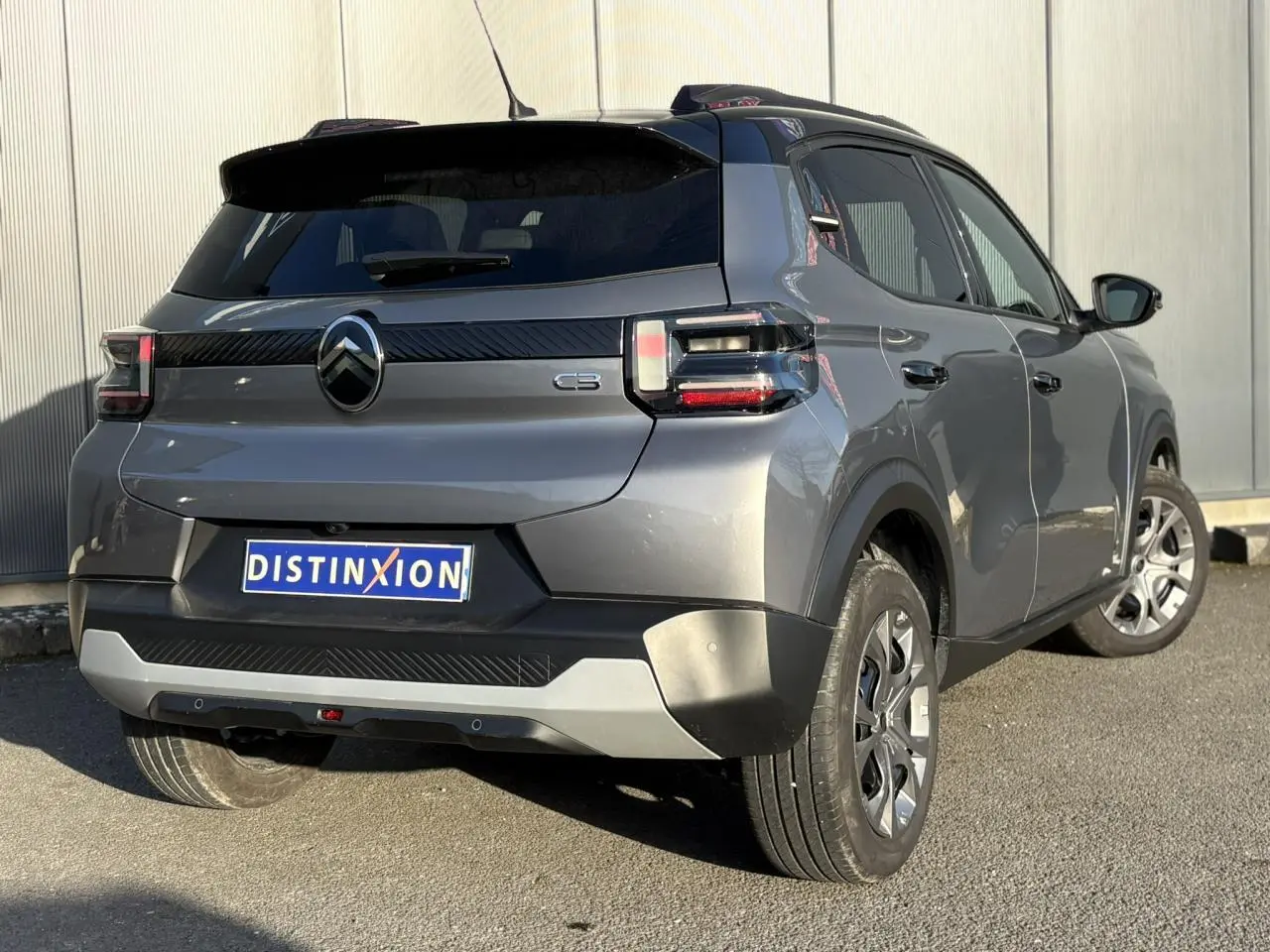 Vue 3/4 arrière droite d'une Citroën C3 2025 gris Mercury avec toit noir et feux arrière LED 3D.