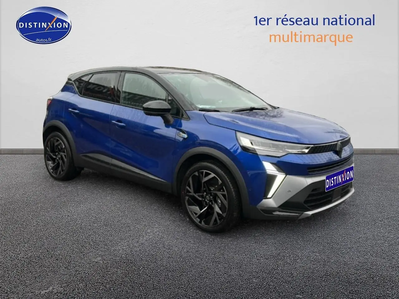 Renault Captur 2025 bleu iron et noir en 3/4 avant, avec jantes noires et toit contrasté noir.
