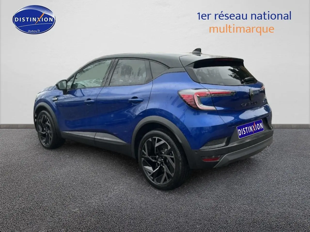 Renault Captur 2025 bleu iron et noir en 3/4 arrière droit, avec jantes alu noires et toit noir contrasté.