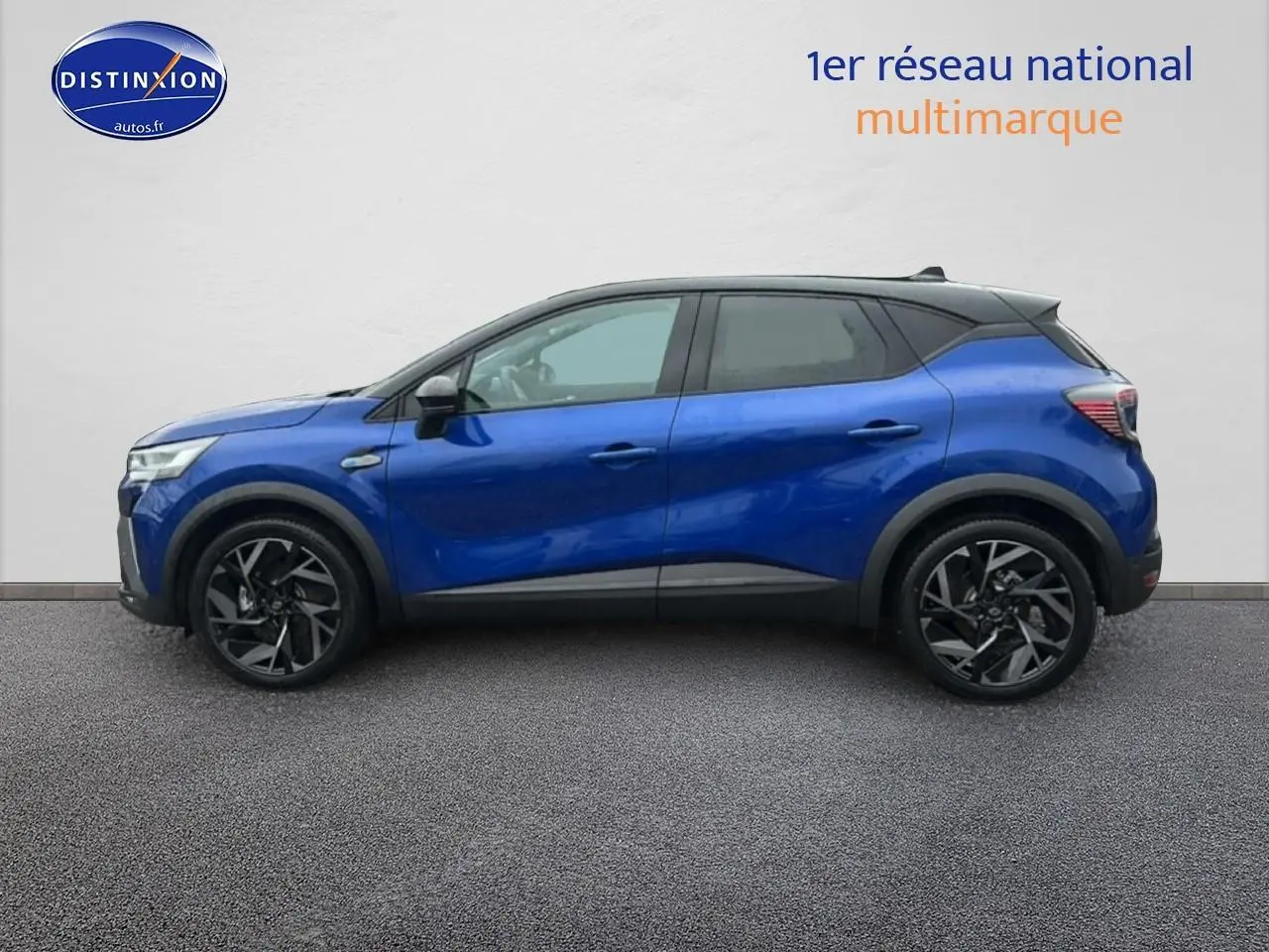 Profil droit du Renault Captur 2025 hybride bleu iron avec toit noir et jantes alu noires.