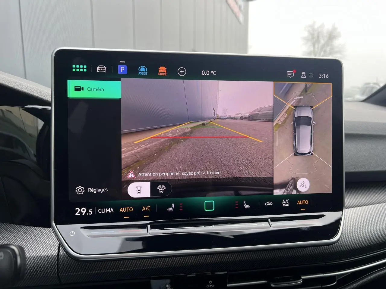 Écran central de la Volkswagen Golf VIII noir montrant la caméra 360° en mode recul avec vue panoramique.