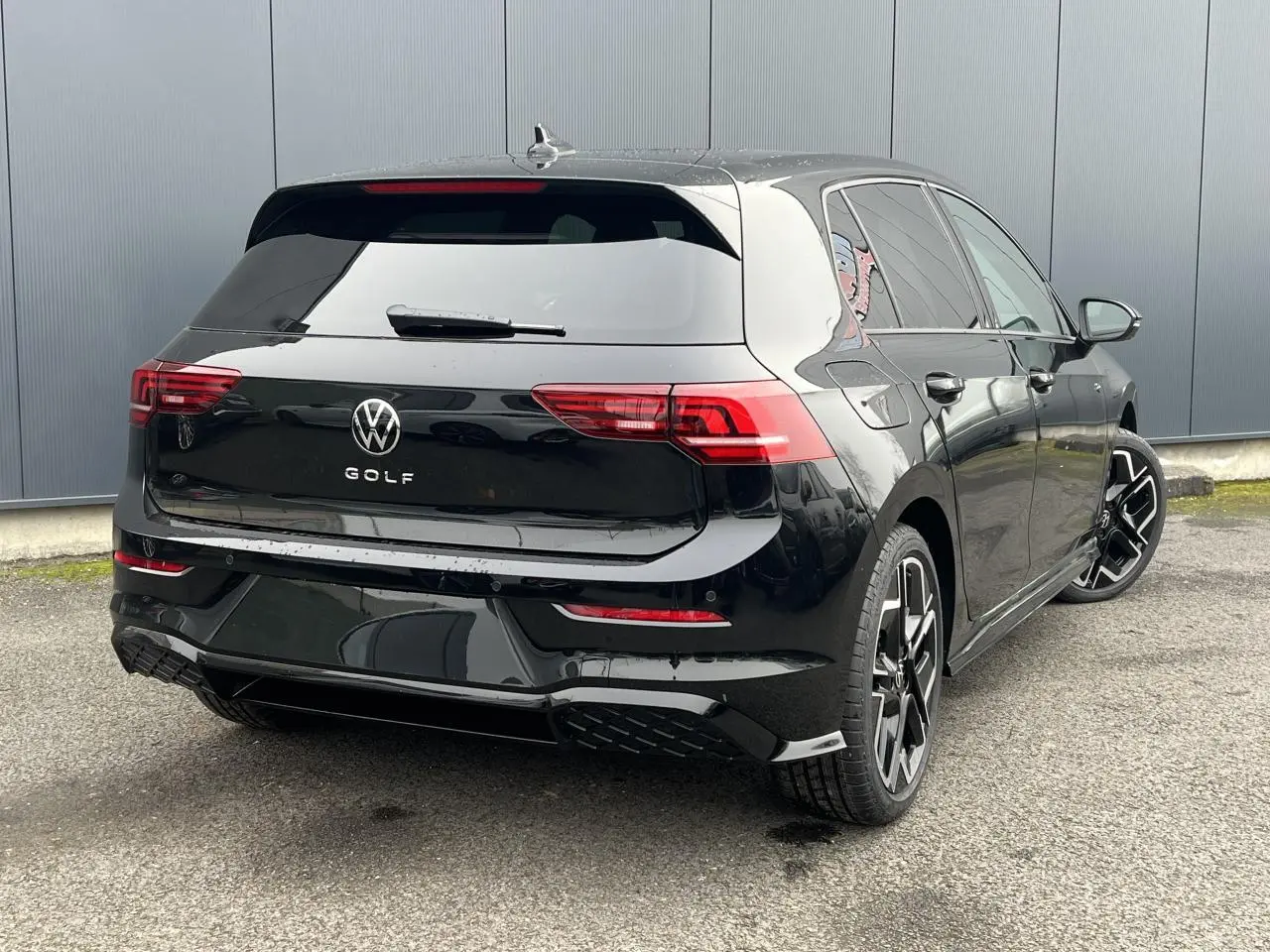 Volkswagen Golf VIII noire vue 3/4 arrière droit avec jantes alliage 18" et toit ouvrant panoramique.