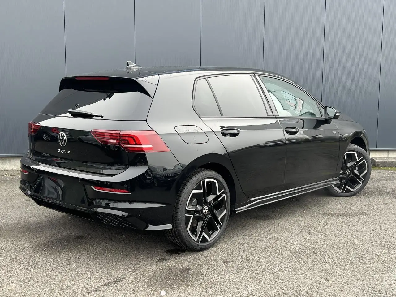 Volkswagen Golf VIII noire vue 3/4 arrière droit, avec jantes alliage 18 pouces et toit ouvrant panoramique.