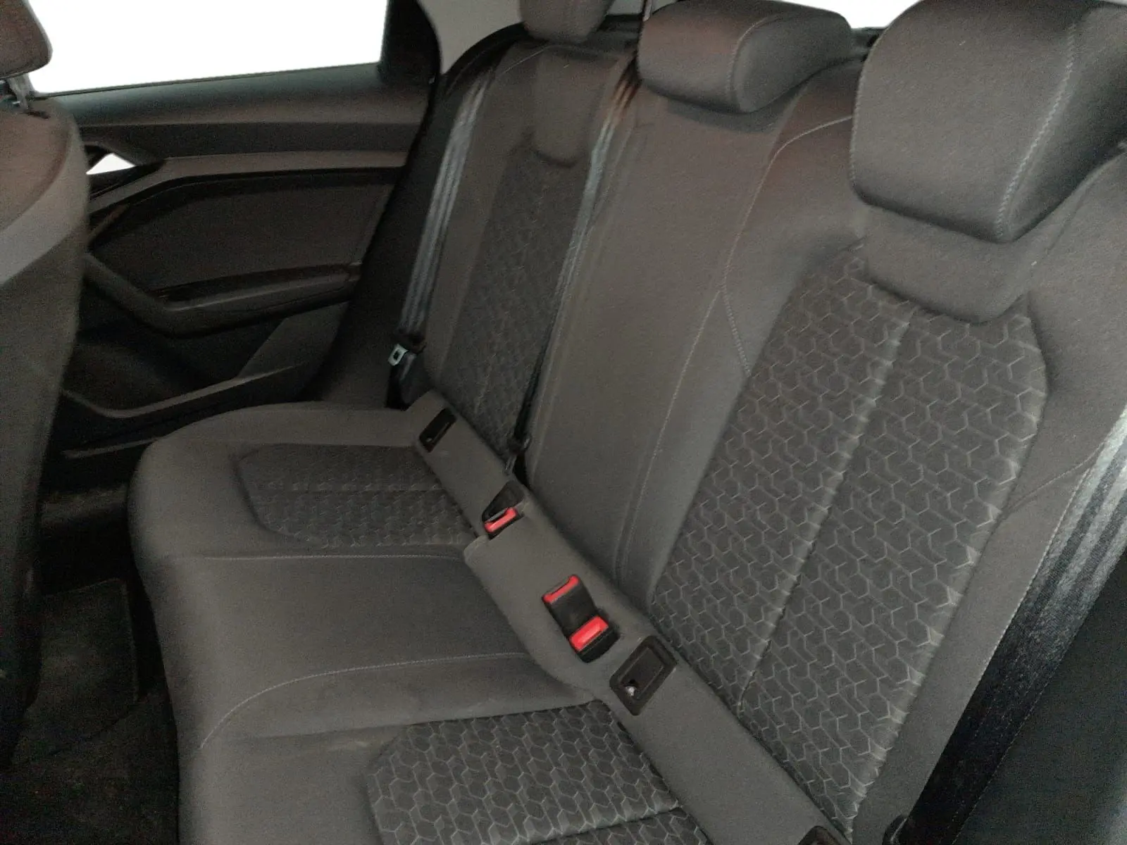 Vue intérieure côté conducteur de l'Audi A1 Sportback 2023, volant cuir noir, tableau de bord digital et levier de vitesse manuel.