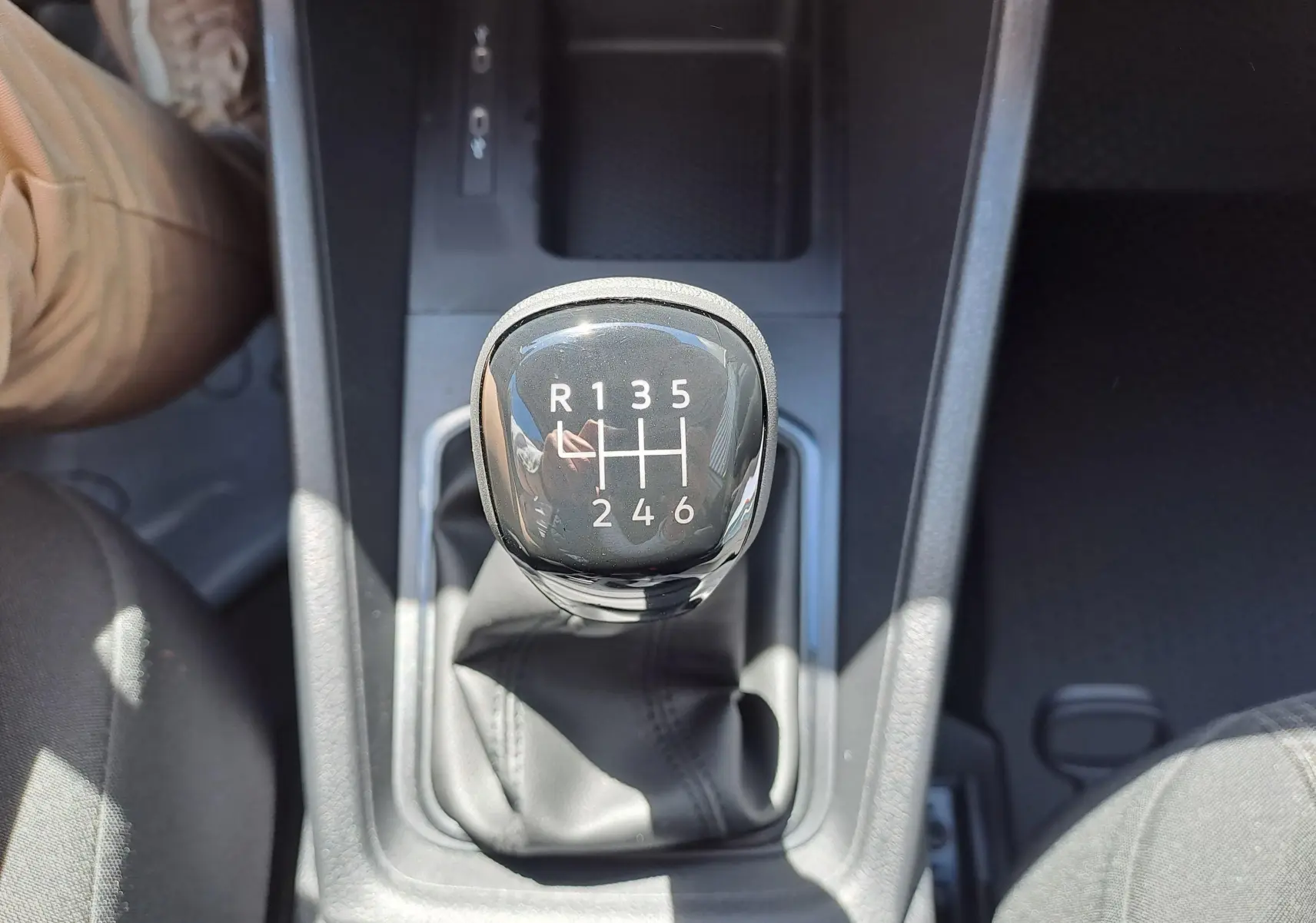 Gros plan sur le levier de vitesse manuel noir du Volkswagen Caddy Cargo Maxi 2026, intérieur avec coutures visibles.