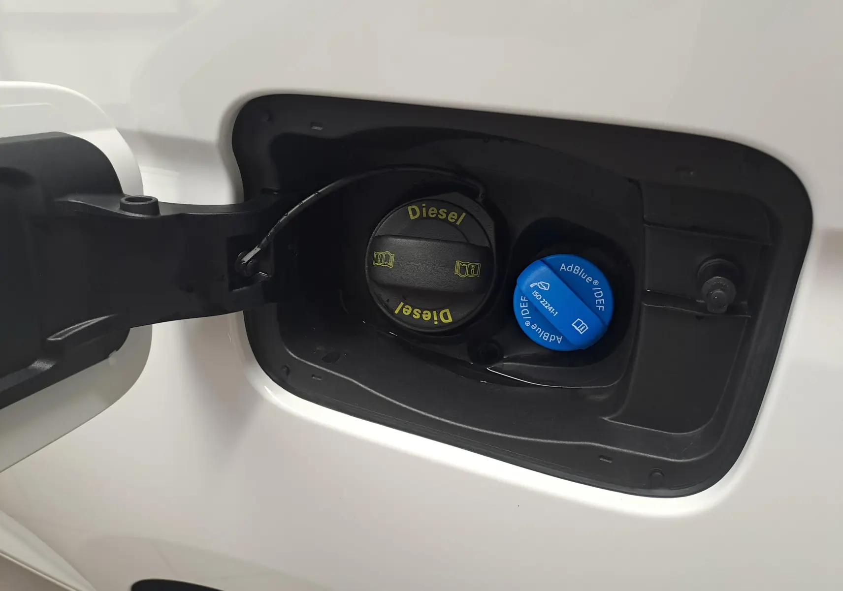 Bouchon de réservoir diesel et AdBlue du Volkswagen Caddy Cargo Maxi blanc Candy, vue rapprochée côté gauche.