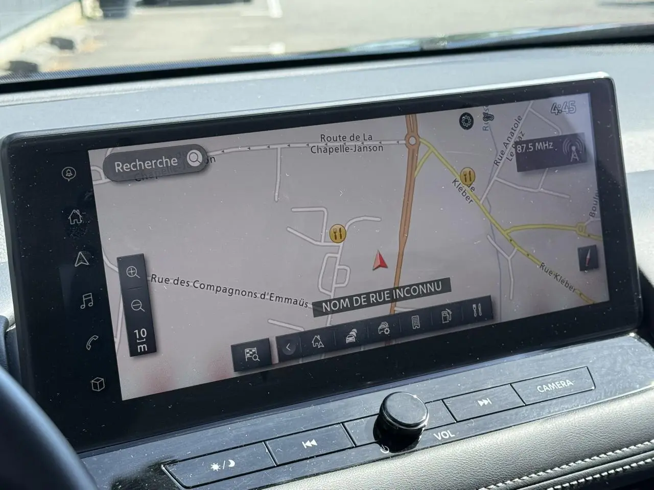 Vue intérieure du tableau de bord du Nissan X-TRAIL 2024, écran tactile affichant la navigation GPS en mode carte.