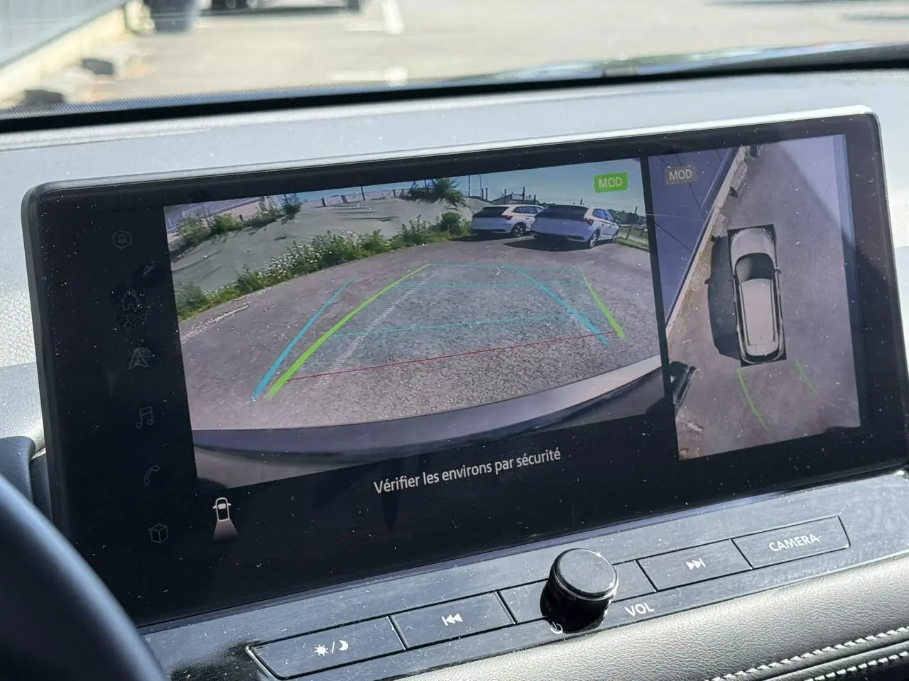 Écran multimédia du Nissan X-TRAIL 2024 montrant la caméra de recul et la vue à 360° en stationnement.