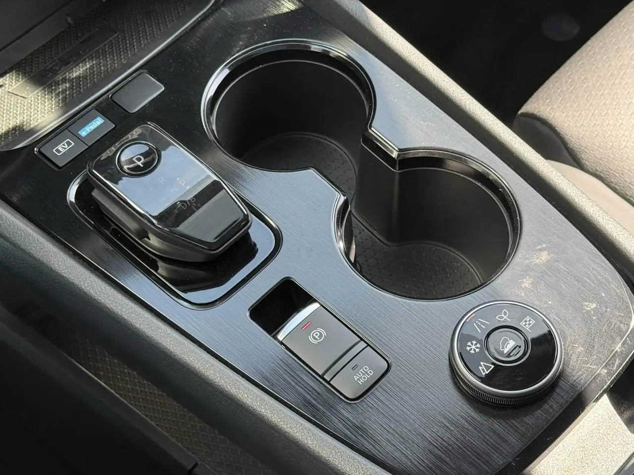 Gros plan sur la console centrale noire du Nissan X-TRAIL 2024 avec sélecteur de boîte auto et commandes de modes de conduite.