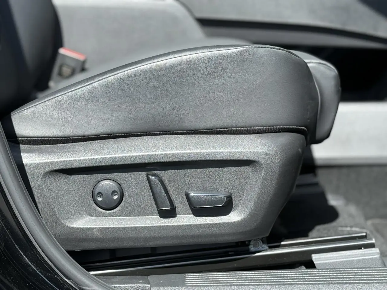 Gros plan sur les commandes électriques du siège avant gauche en cuir noir du Nissan X-TRAIL 2024.