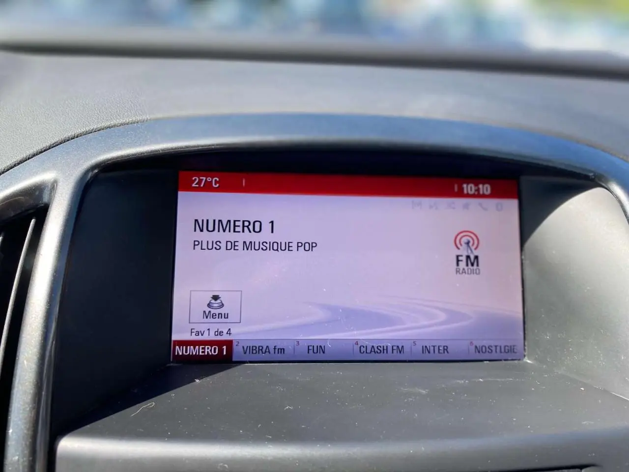 Écran central de l’Opel Astra Sports Tourer 2014 affichant la radio FM sur fond gris, vue de face rapprochée.
