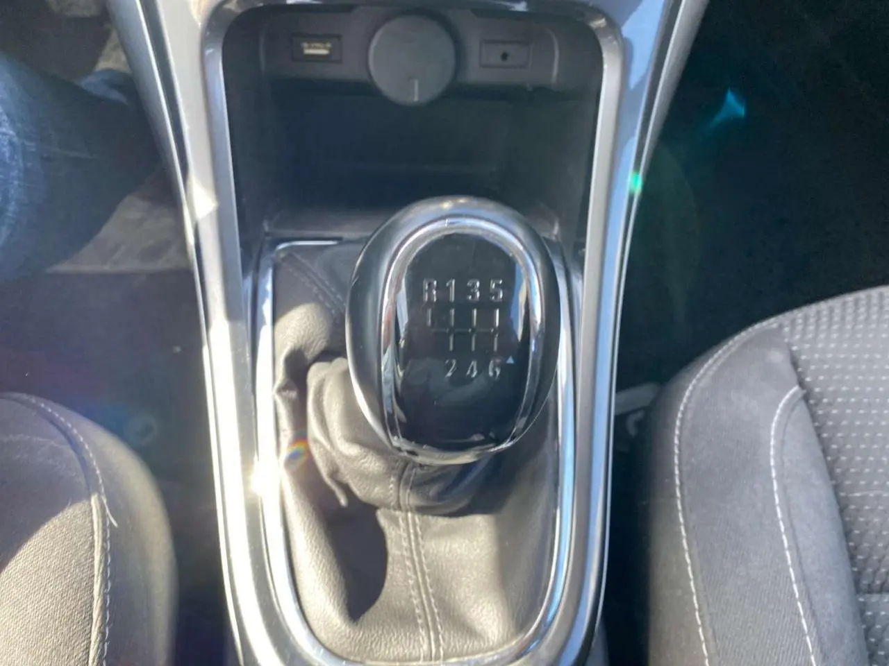 Gros plan sur le levier de vitesses manuel noir de l’Opel Astra Sports Tourer gris, avec indication des 6 rapports visibles.