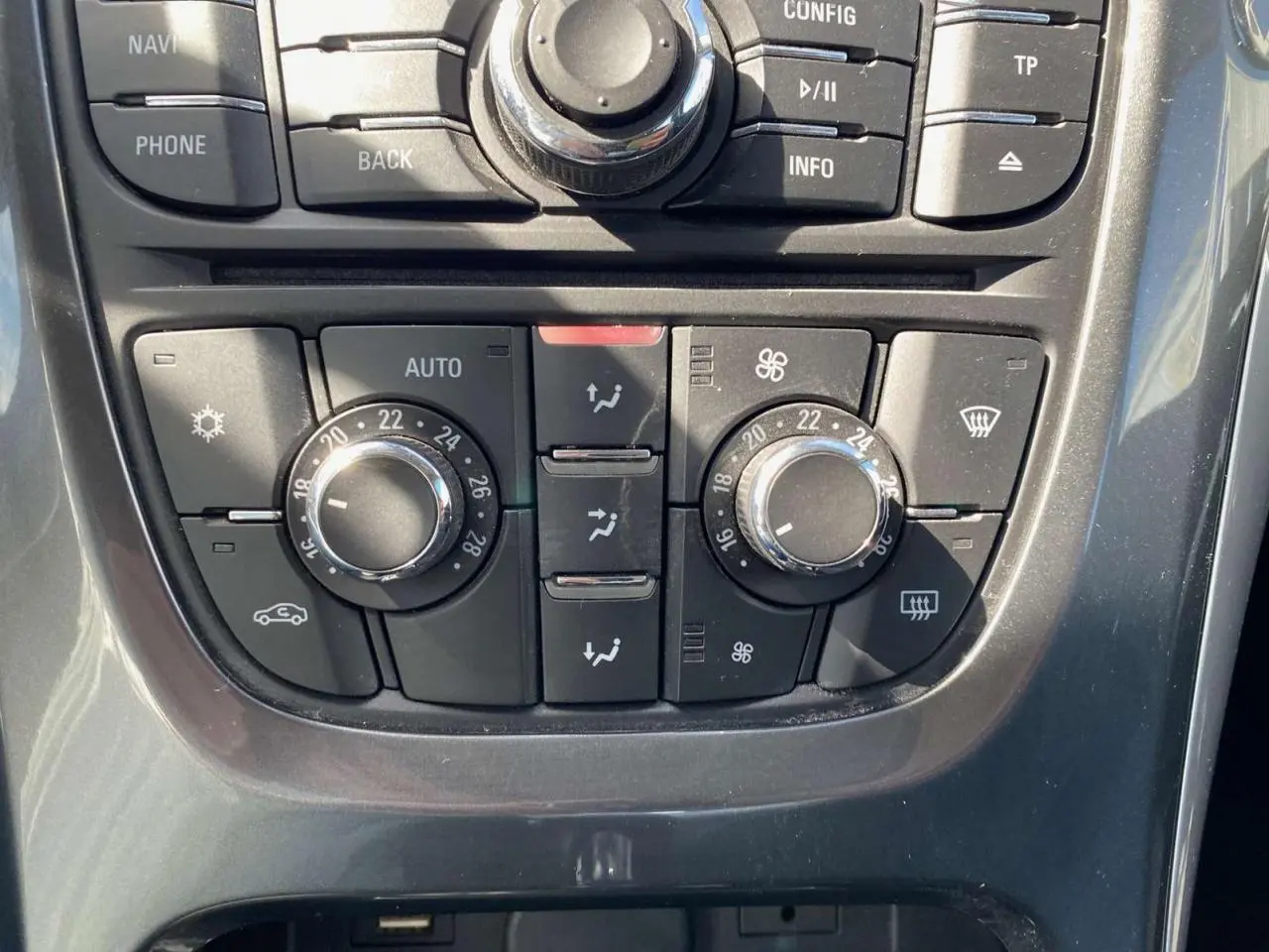 Vue rapprochée du tableau de commande de climatisation de l’Opel Astra Sports Tourer gris 2014 avec réglages manuels.