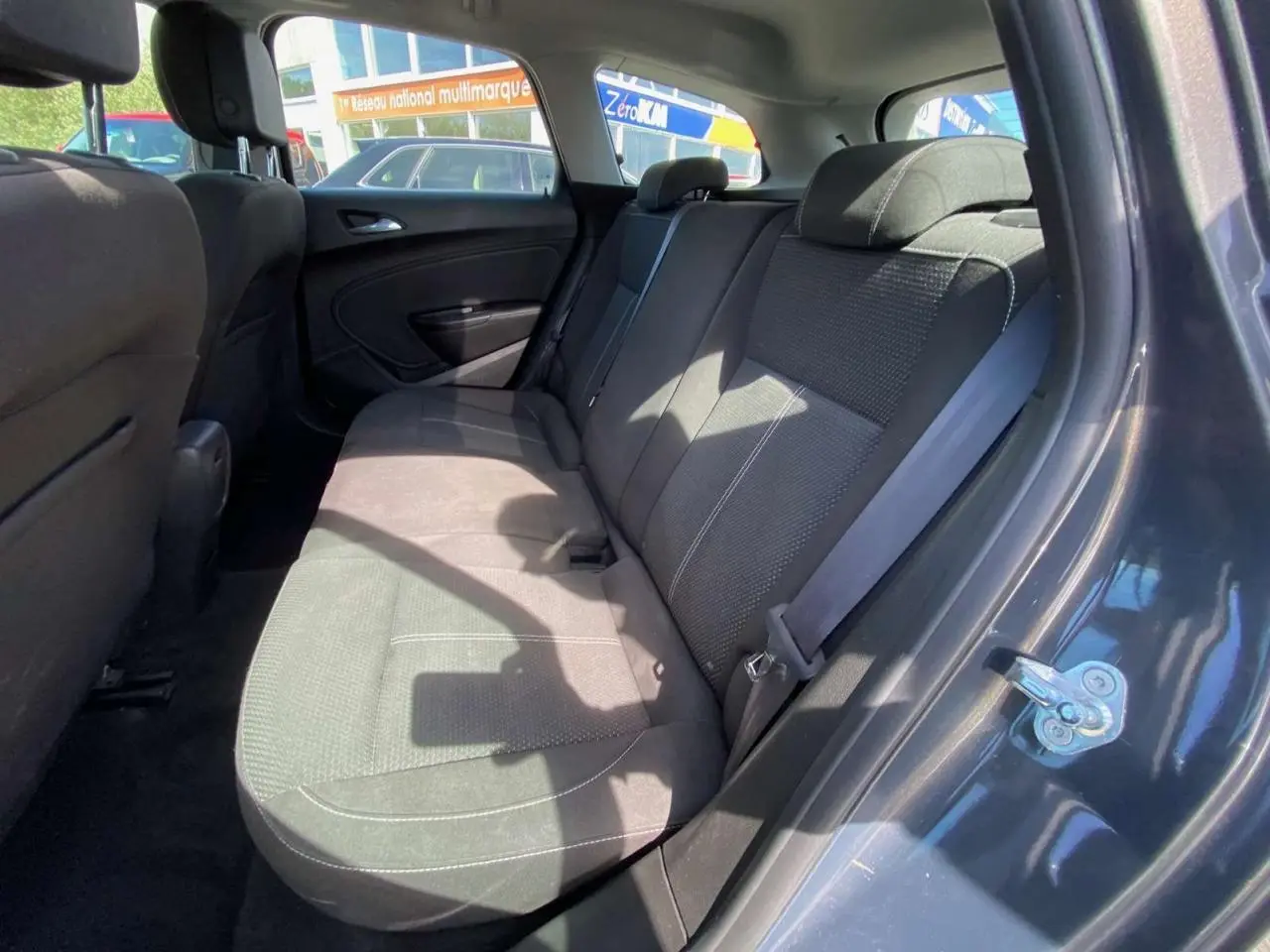 Vue intérieure côté droit sur les sièges arrière en tissu gris de l’Opel Astra Sports Tourer 2014.
