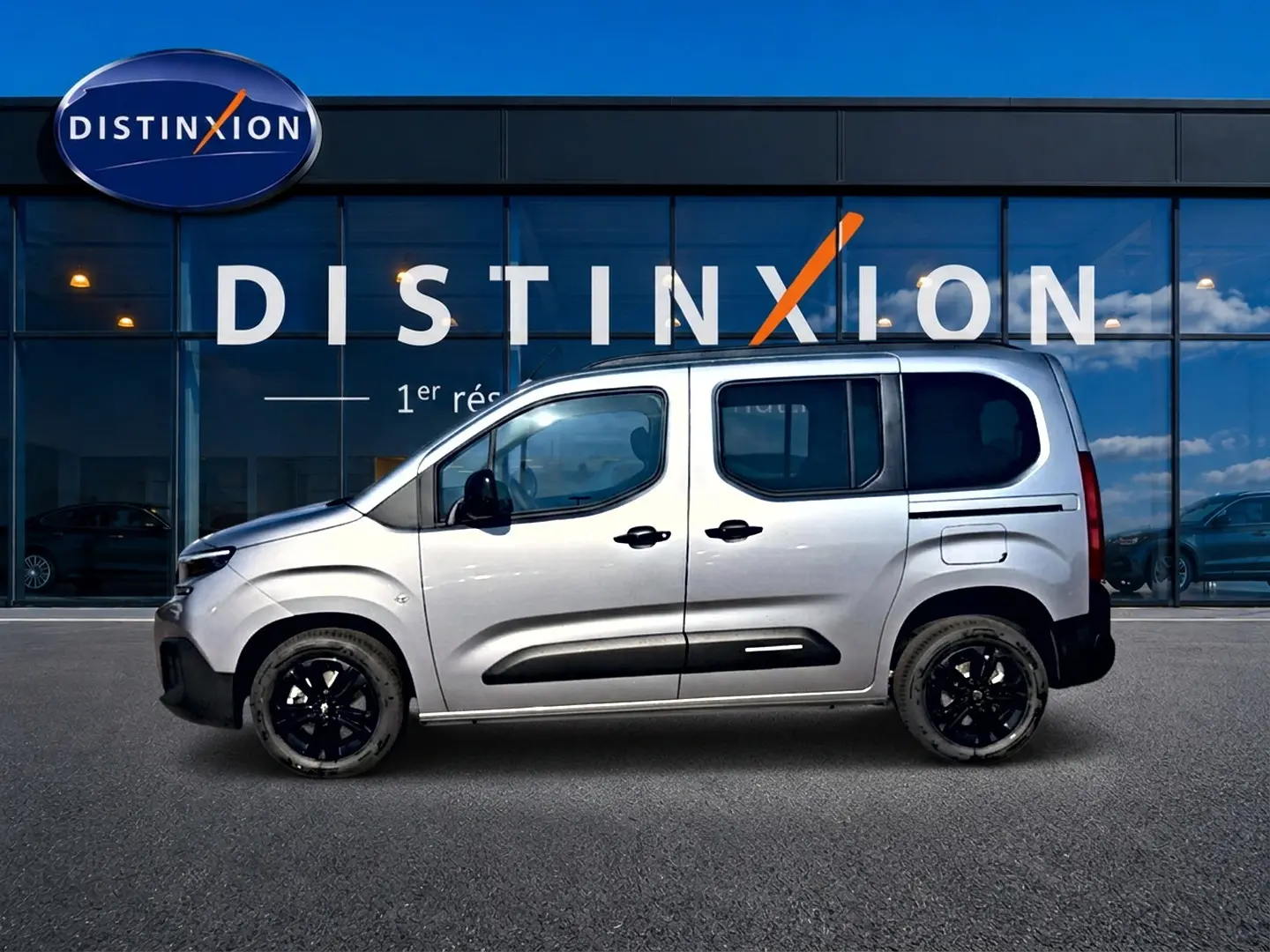 Vue latérale droite d'un Citroën Berlingo 2026 gris acier avec jantes noires et protections latérales noires.