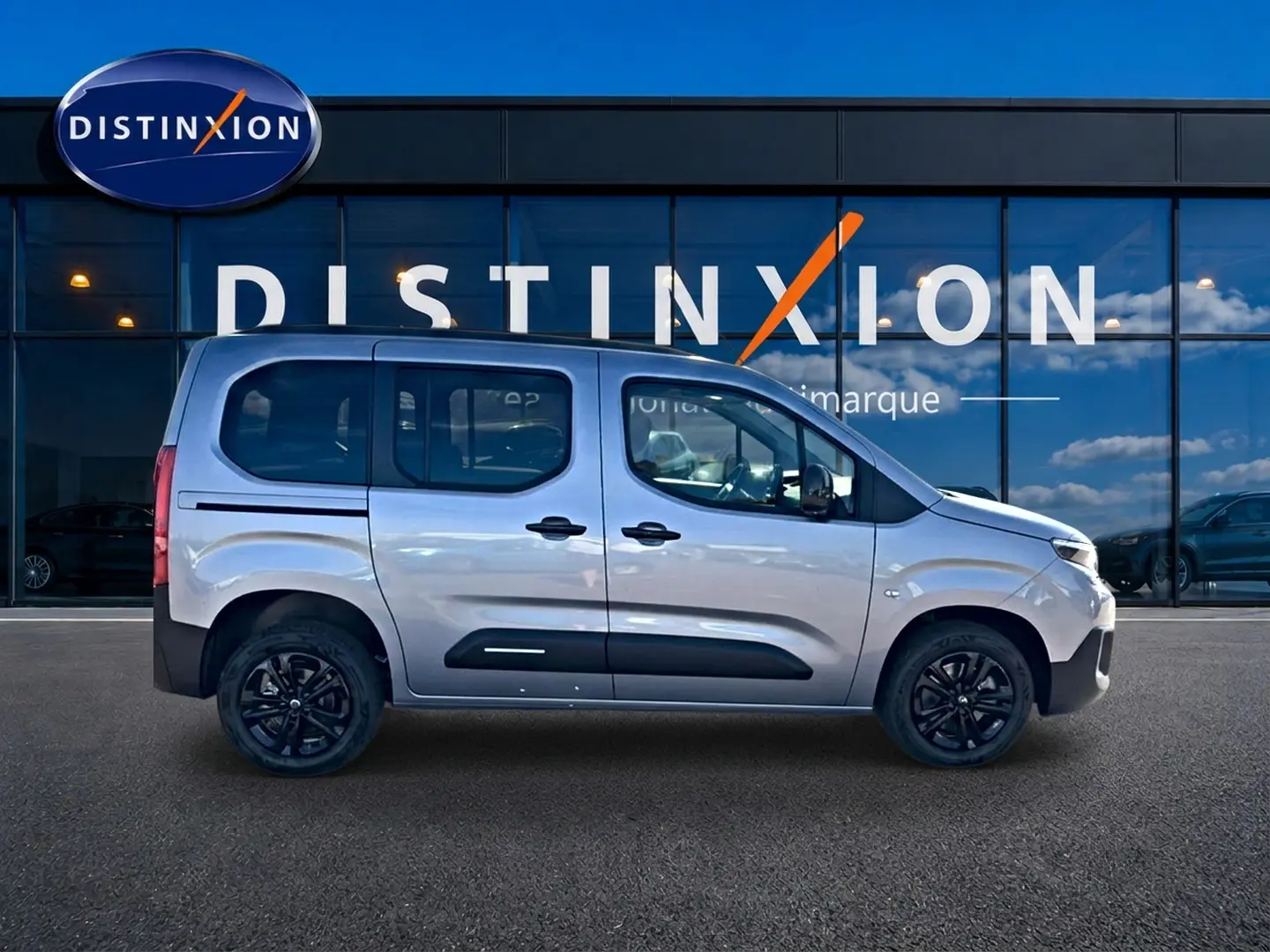 Vue de profil droit du Citroën Berlingo Steel Grey 2026 avec barres de toit et jantes noires.