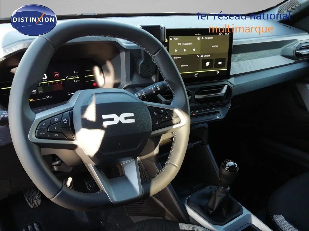 Vue intérieure du poste de conduite du Dacia Duster TCE MHEV 140ch Journey 2026, volant multifonction et écran tactile central.