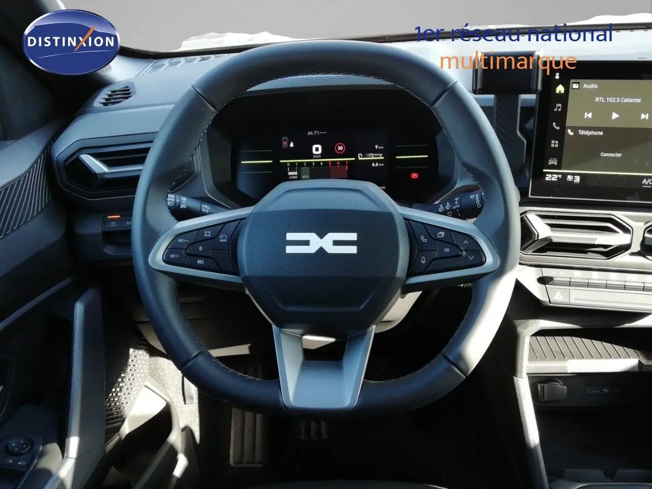 Vue intérieure centrée sur le volant multifonction du Dacia Duster 2026, avec tableau de bord digital et écran tactile.